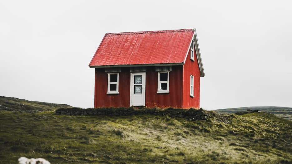 Kleines rotes Haus auf einem Hügel, symbolisiert das Ziel vom Eigenheim durch einen Bausparvertrag