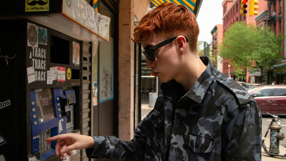 Person bezieht Bargeld an einem Terminal