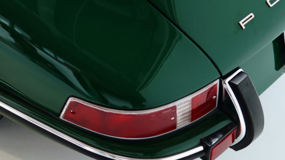 Elegantes Heck eines dunkelgrünen Klassikers mit roten Rückleuchten - ein Traumfahrzeug, finanzierbar durch einen flexiblen Ratenkredit.